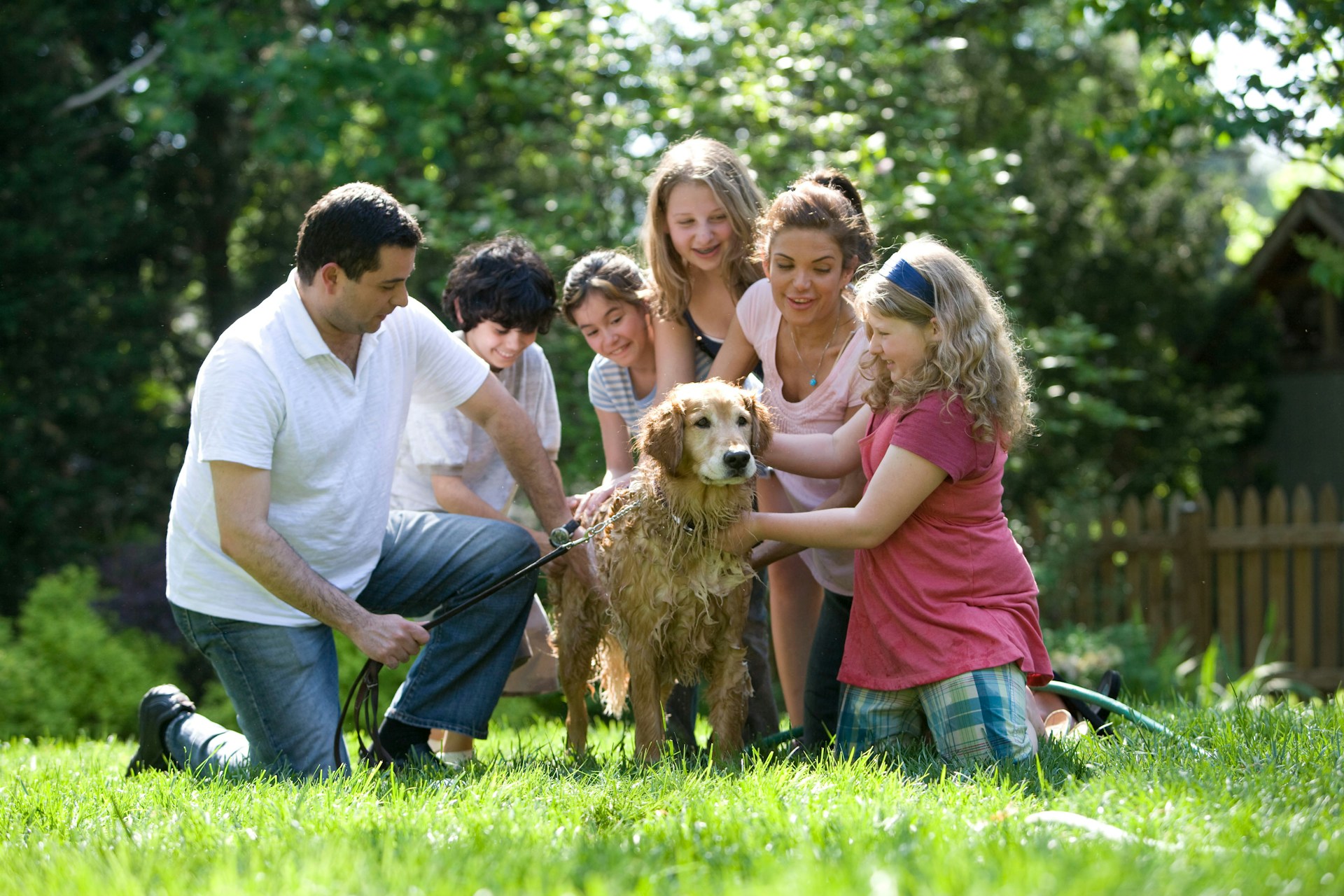 a family surrounding a dog - how to reserve a puppy from pilesgrove pups